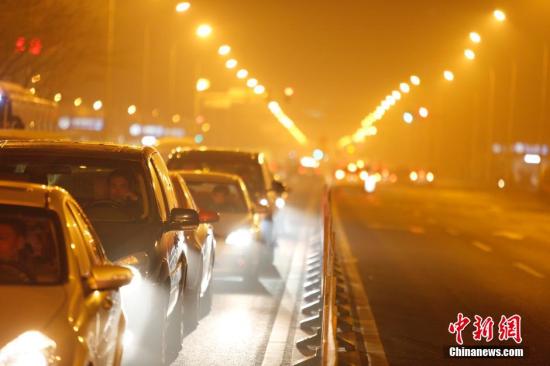 12月8日晚间，雾霾笼罩下的北京长安街晚高峰车流。